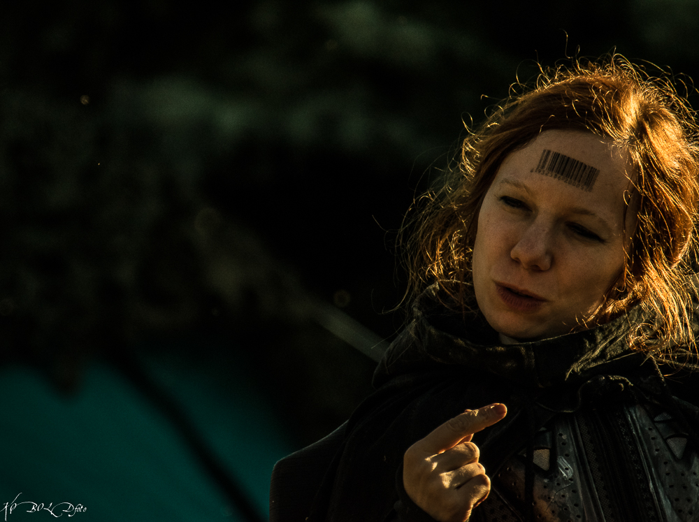 Ein seltener Anblick: Eine Chronistin ohne Maske. Das für den Kult typische Barcode-Tattoo auf ihrer Stirn ist gut zu erkennen.